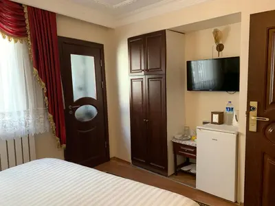 a bedroom with a bed and a television and a cabinet at Ada Hotel Istanbul in Istanbul