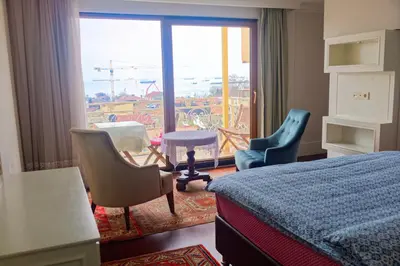 a hotel room with a bed and chairs and a window at Ada Hotel Istanbul in Istanbul