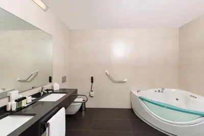 a bathroom with a tub and a toilet and a sink at Nippon Hotel in Istanbul