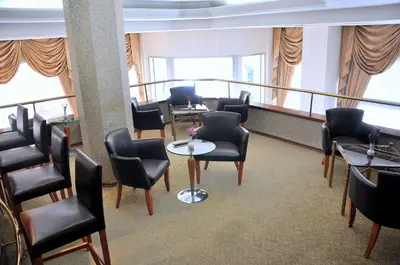 a waiting room with chairs and tables and windows at Hotel Centrum Istanbul in Istanbul