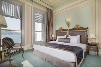 a bedroom with a large bed and a chair and windows at Bosphorus Palace Hotel in Istanbul
