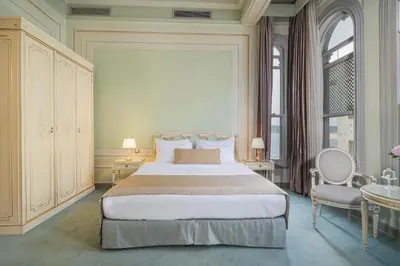 a bedroom with a bed and two chairs and a window at Bosphorus Palace Hotel in Istanbul