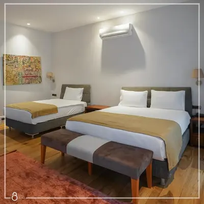 a hotel room with two beds and a rug at Misafir Suites 8 Istanbul in Istanbul