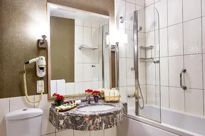 a bathroom with a sink and a shower and a toilet at Güneş Hotel Merter in Istanbul