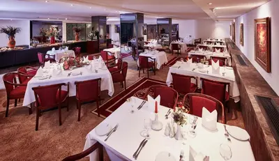 a restaurant with white tables and red chairs at Güneş Hotel Merter in Istanbul
