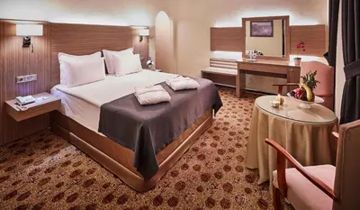 a hotel room with a bed and a desk at Güneş Hotel Merter in Istanbul