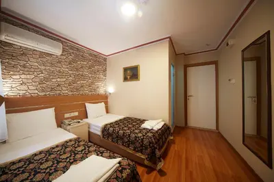 a hotel room with two beds and a stone wall at Hotel Akcinar in Istanbul