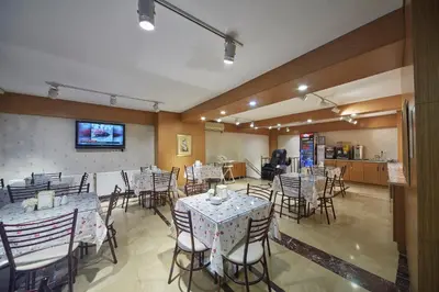 a dining room with tables and chairs and a tv at Hotel Akcinar in Istanbul