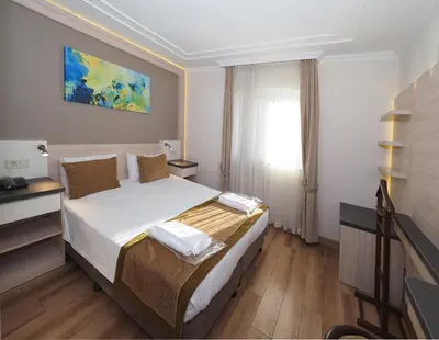 a bedroom with a bed in a room with a window at Hotel Bulvar Palas in Istanbul