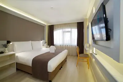a hotel room with a bed and a flat screen tv at Hotel Bulvar Palas in Istanbul