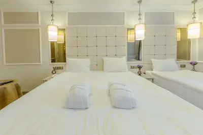 a bedroom with a large white bed with two white slippers at The Constantine Hotel in Istanbul