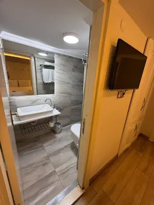 a bathroom with a toilet and a sink and a tv at The Constantine Hotel in Istanbul