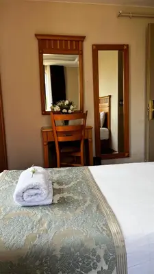 a bedroom with a bed and a desk and a mirror at Park Star Hotel Taksim in Istanbul