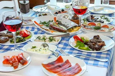 a table with plates of food and glasses of wine at Hotel Troya Balat in Istanbul