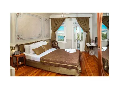 a bedroom with a king sized bed and windows at Hotel Troya Balat in Istanbul