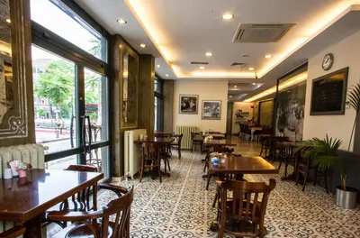 a restaurant with tables and chairs and windows at Hotellino Istanbul in Istanbul
