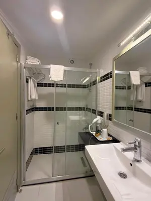 a bathroom with a glass shower and a sink at Hotellino Istanbul in Istanbul