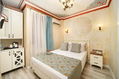 a bedroom with a white bed and a white cabinet at Aldem Hotel in Istanbul