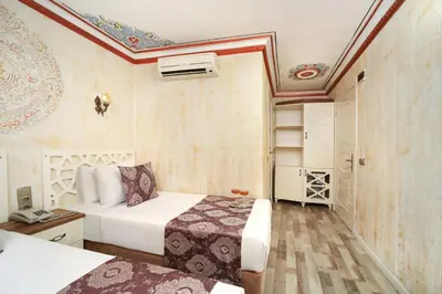 a bedroom with two beds in a room with a ceiling at Aldem Hotel in Istanbul