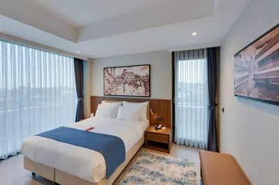 a hotel room with a large bed and large windows at Ramada by Wyndham Istanbul Old City in Istanbul