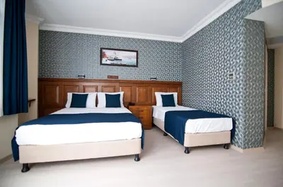 two beds in a room with blue and white wallpaper at Artefes Hotel Old City in Istanbul