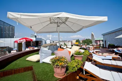 a patio with a white umbrella and chairs on a roof at Klas Hotel Istanbul Old City in Istanbul