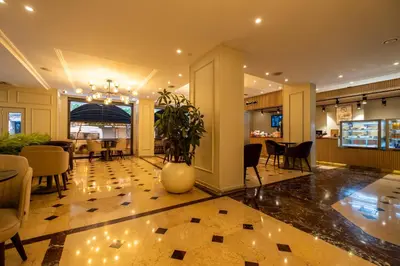 a lobby with a table and chairs and a vase with a plant at Berr Hotel in Istanbul