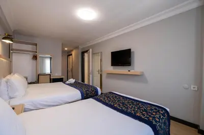 a hotel room with two beds and a flat screen tv at Berr Hotel in Istanbul