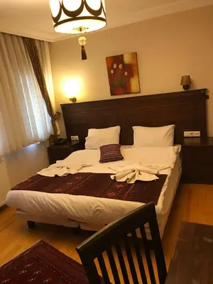 a bedroom with a large bed with white sheets at Berce Apartments in Istanbul