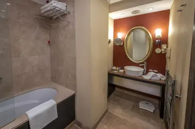 a bathroom with a tub and a sink and a mirror at Agaoğlu My City Hotel Istanbul in Istanbul