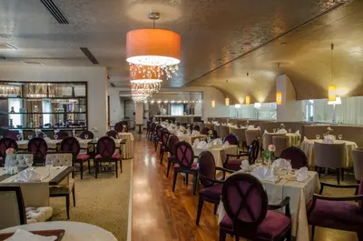 a dining room with tables and chairs and a chandelier at Agaoğlu My City Hotel Istanbul in Istanbul