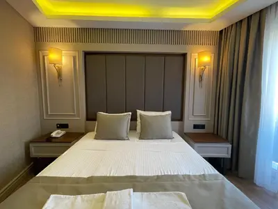 a bedroom with a large white bed with two tables at Martinenz Hotel in Istanbul