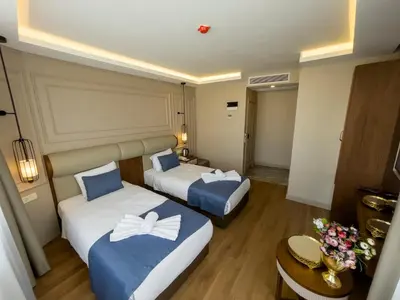 a hotel room with two beds and a table at Martinenz Hotel in Istanbul