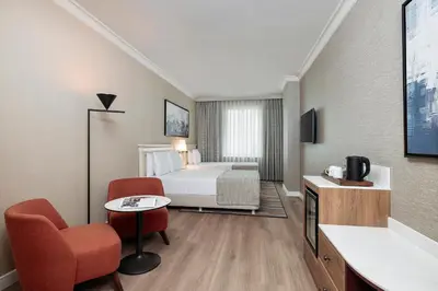 a hotel room with a bed and a chair at Elite World Comfy Istanbul Taksim in Istanbul