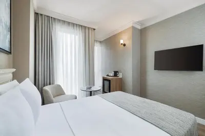 a hotel room with a bed and a flat screen tv at Elite World Comfy Istanbul Taksim in Istanbul
