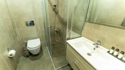 a bathroom with a shower and a sink and a toilet at The Marmara Suadiye Residence in Istanbul