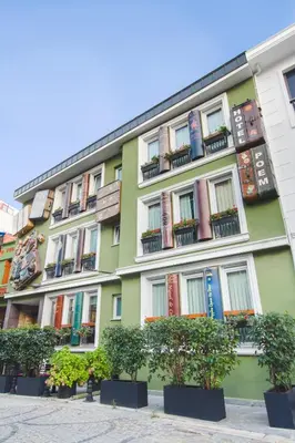 a green building with potted trees in front of it at Hotel Poem in Istanbul