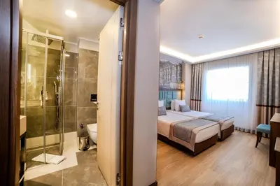 a bedroom with a bed and a bathroom with a shower at Grand Hilarium Hotel in Istanbul