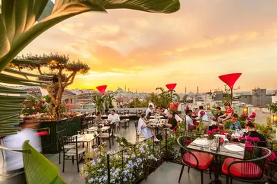 a group of people sitting at tables on a rooftop restaurant at Seres Hotel Old City in Istanbul