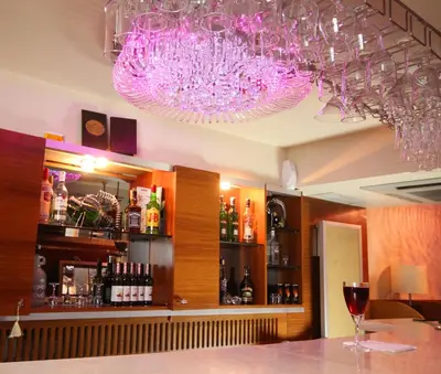 a bar with purple chandeliers and a counter with wine glasses at Royce Hotel in Istanbul
