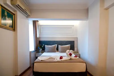 two swans sitting on a bed in a room at Royce Hotel in Istanbul