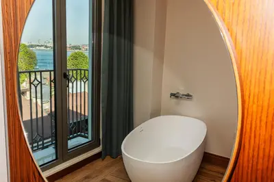 a bathroom with a toilet in front of a window at Triton Hotel in Istanbul