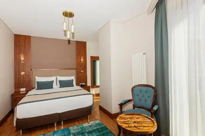 a bedroom with a bed and a chair at Triton Hotel in Istanbul