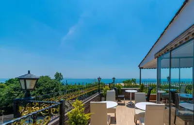 a balcony with tables and chairs and a view of the ocean at Harmony Hotel Istanbul & SPA in Istanbul