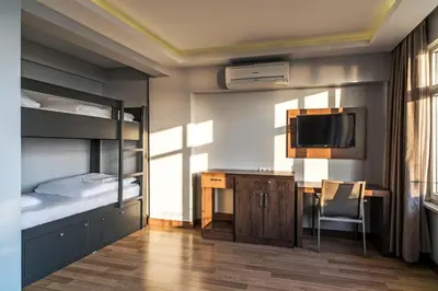 a bedroom with bunk beds and a desk and a tv at Bucoleon by Cheers in Istanbul