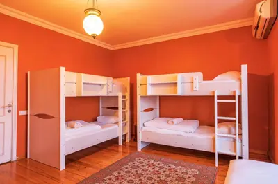 two bunk beds in a room with orange walls at Bucoleon by Cheers in Istanbul