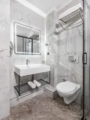 a white bathroom with a sink and a toilet at Hotel Bristol in Istanbul