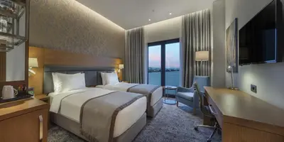 a hotel room with two beds and a desk at Holiday Inn Istanbul - Tuzla Bay by IHG in Istanbul