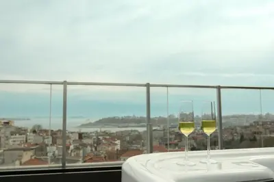 two glasses of white wine sitting on top of a table at Louis Rooms in Istanbul
