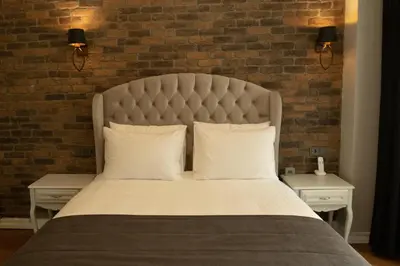 a bedroom with a large bed with a brick wall at Louis Rooms in Istanbul